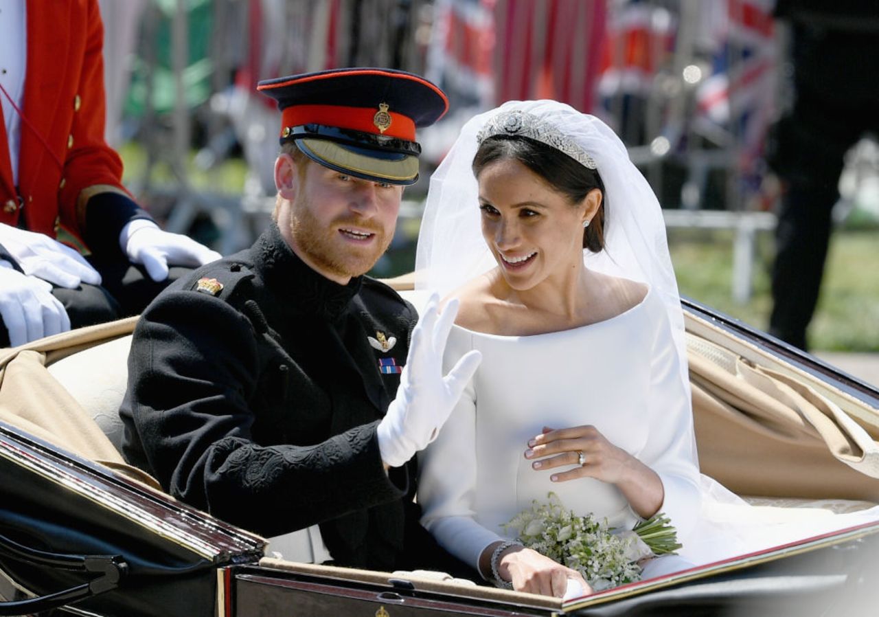 Britain's Prince Harry, Duke of Sussex and his wife Meghan, Duchess of Sussex wave from the Ascot Landau Carriage during their carriage procession on the Long Walk as they head back towards Windsor Castle in Windsor, on May 19, 2018 after their wedding ceremony. 