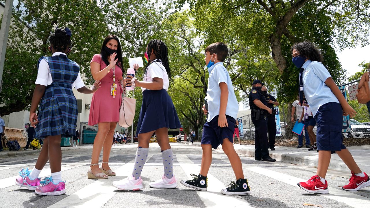 A teacher greets students outside of a school in Miami on August 23.