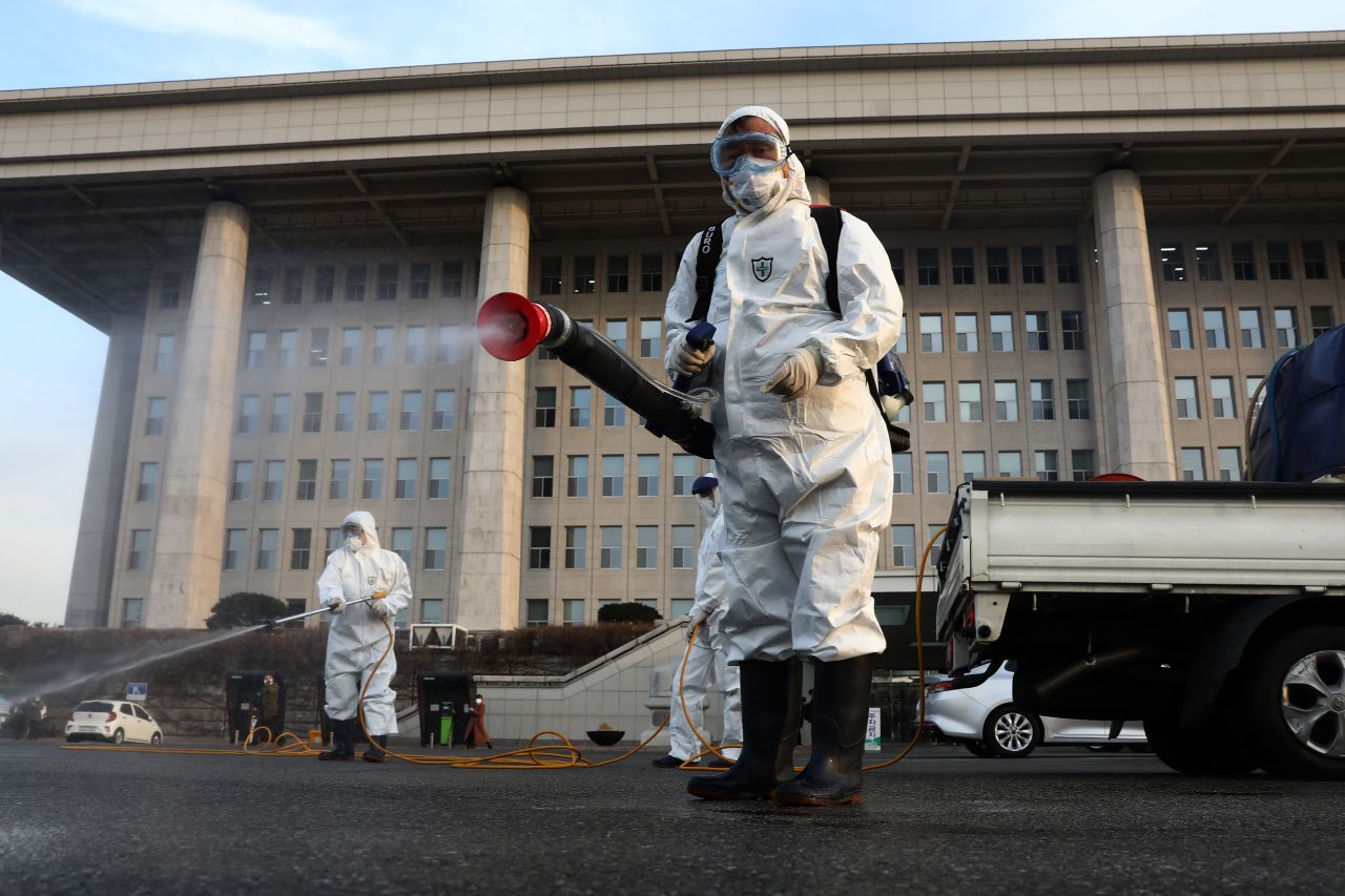 Disinfection workers wearing protective gear spray antiseptic solution against the coronavirus in Seoul, South Korea.?