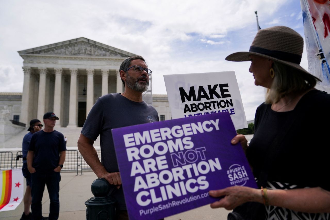 Anti-abortion protesters hold placards outside the US Supreme Court in Washington, DC, on Thursday.