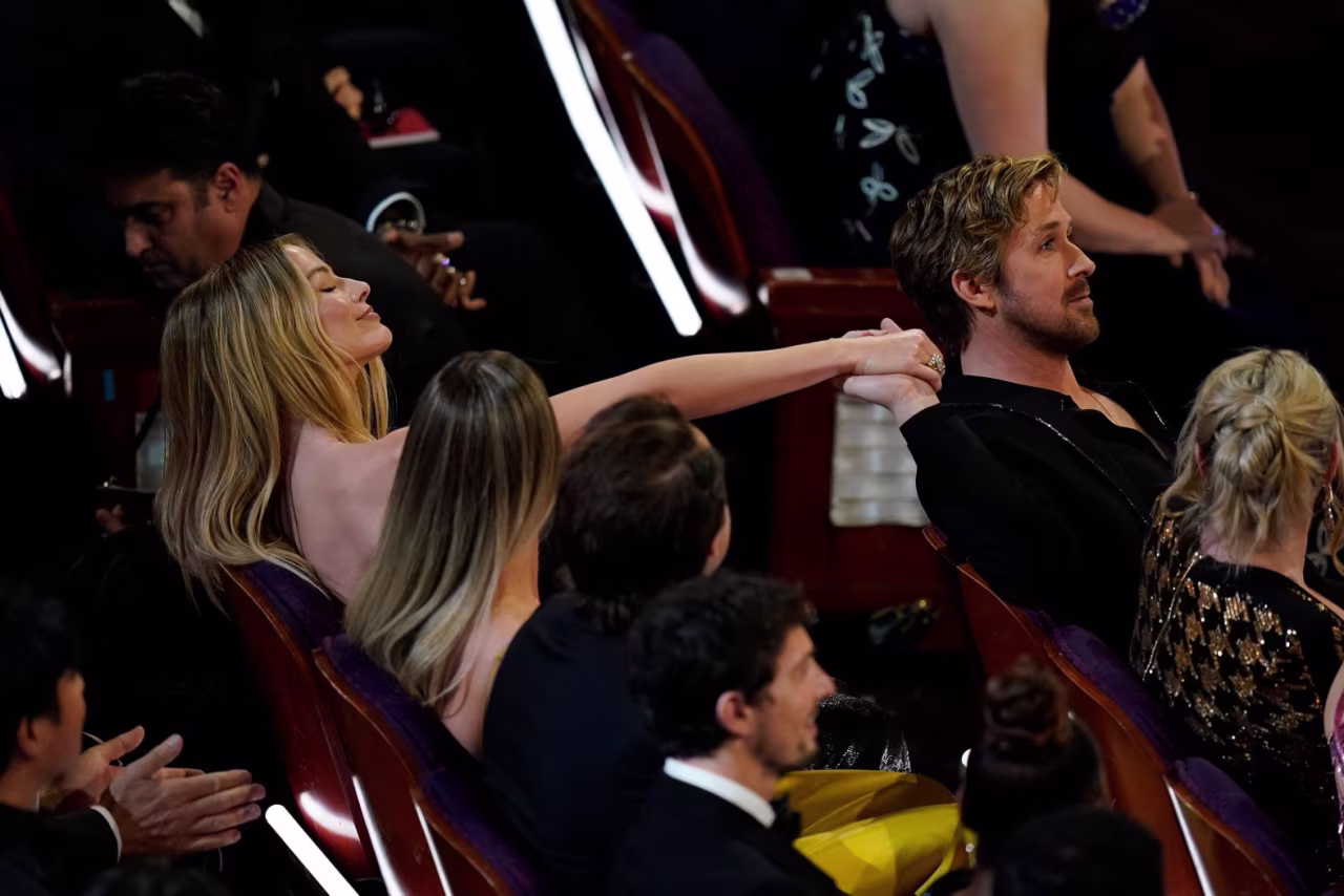 Gosling and "Barbie" co-star Margot Robbie hold hands during the show. 