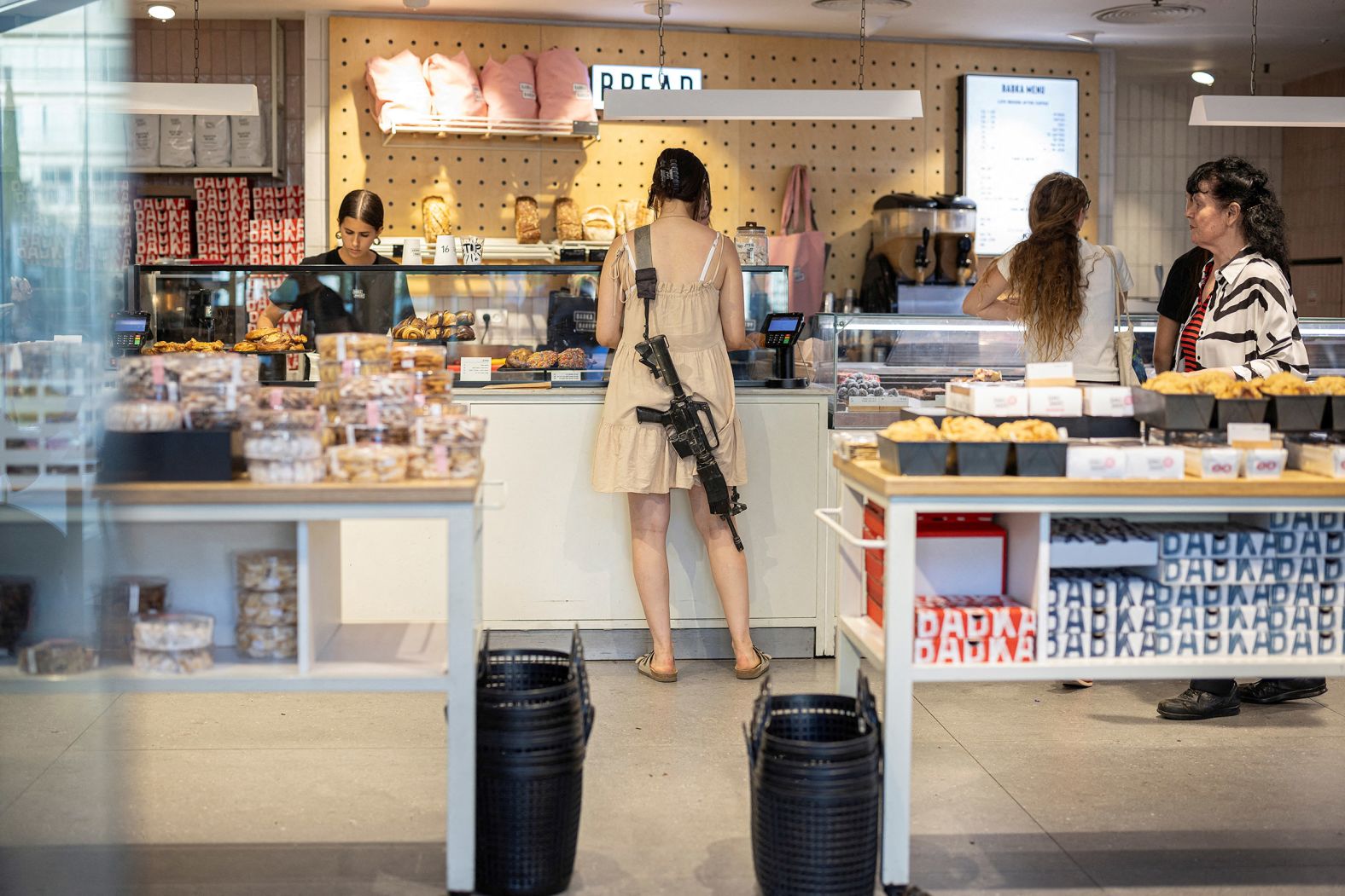 A woman with a rifle shops in a bakery in Tel Aviv, Israel, on June 4.