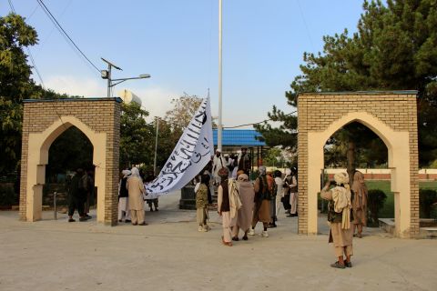 Taliban fighters raise their flag at the Ghazni provincial governor's house in Ghazni, Afghanistan, on August 15, 2021.