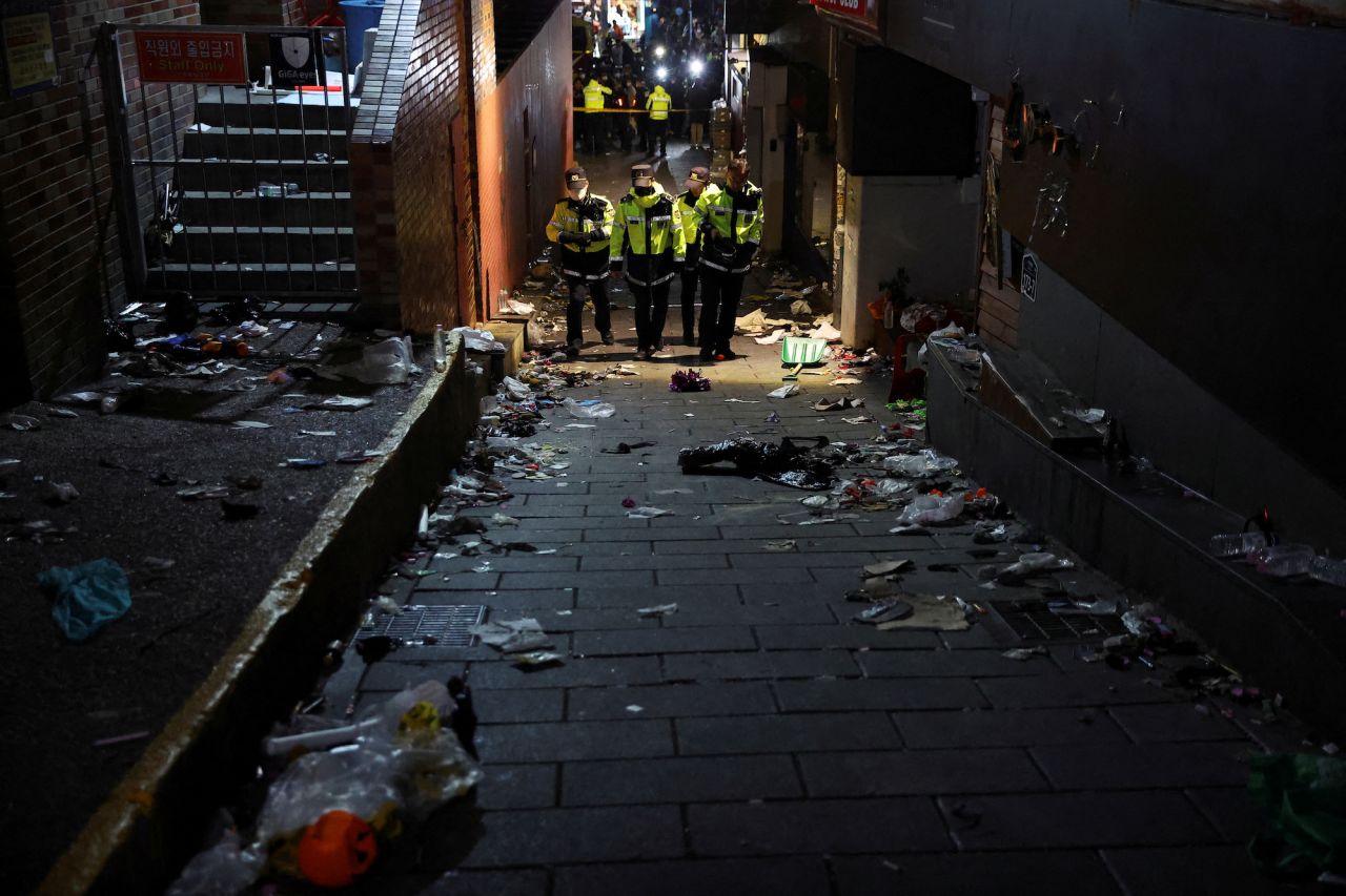 Police officers walk down the narrow alleyway in Itaewon on Saturday night.