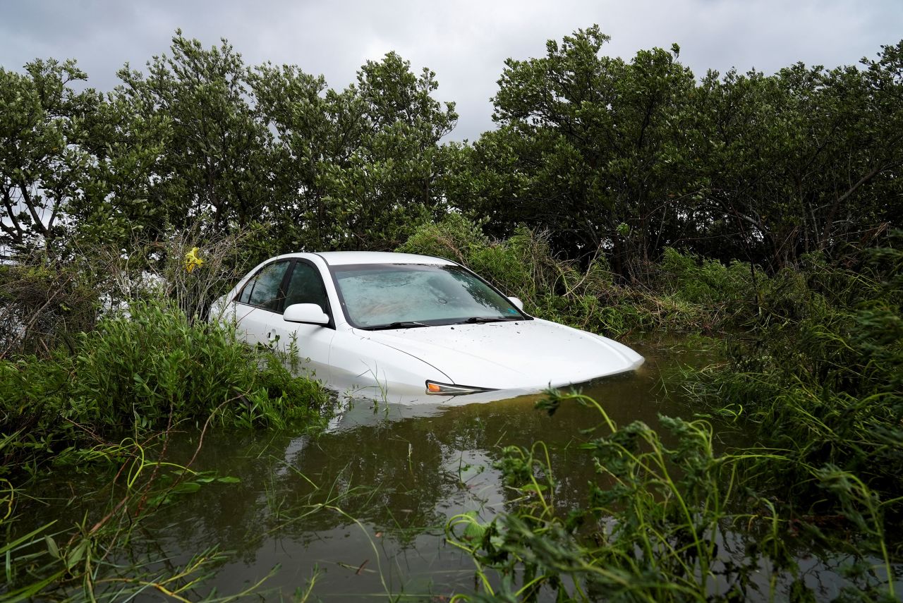 A vehicle is partially submerged in flood waters in Cedar Key, Florida.