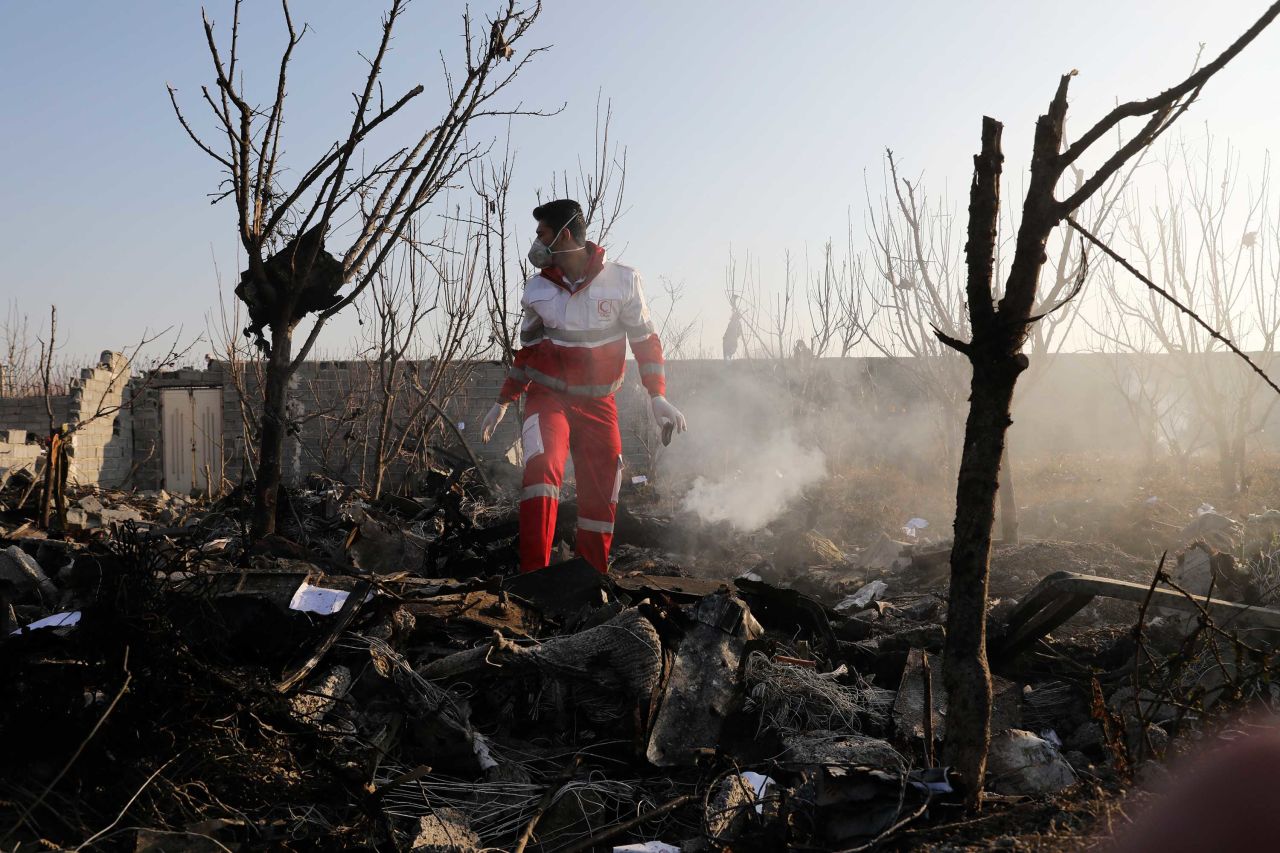 A rescue worker searches the scene of the crash in Shahedshahr, Iran on Wednesday.