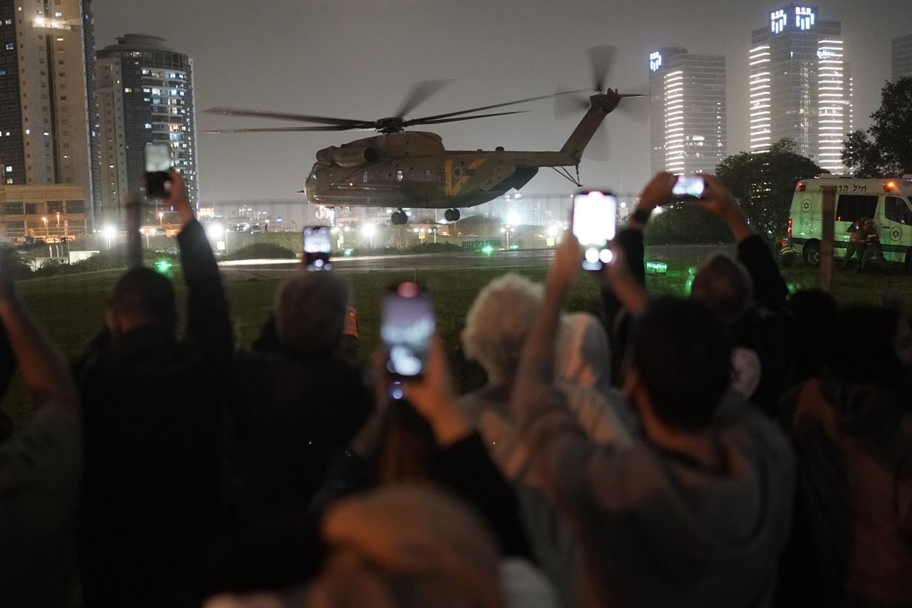 A group of Israelis watch as a helicopter carrying hostages released from Gaza lands at the helipad of the Schneider Children's Medical Center in Petah Tikva, Israel, on November 26.