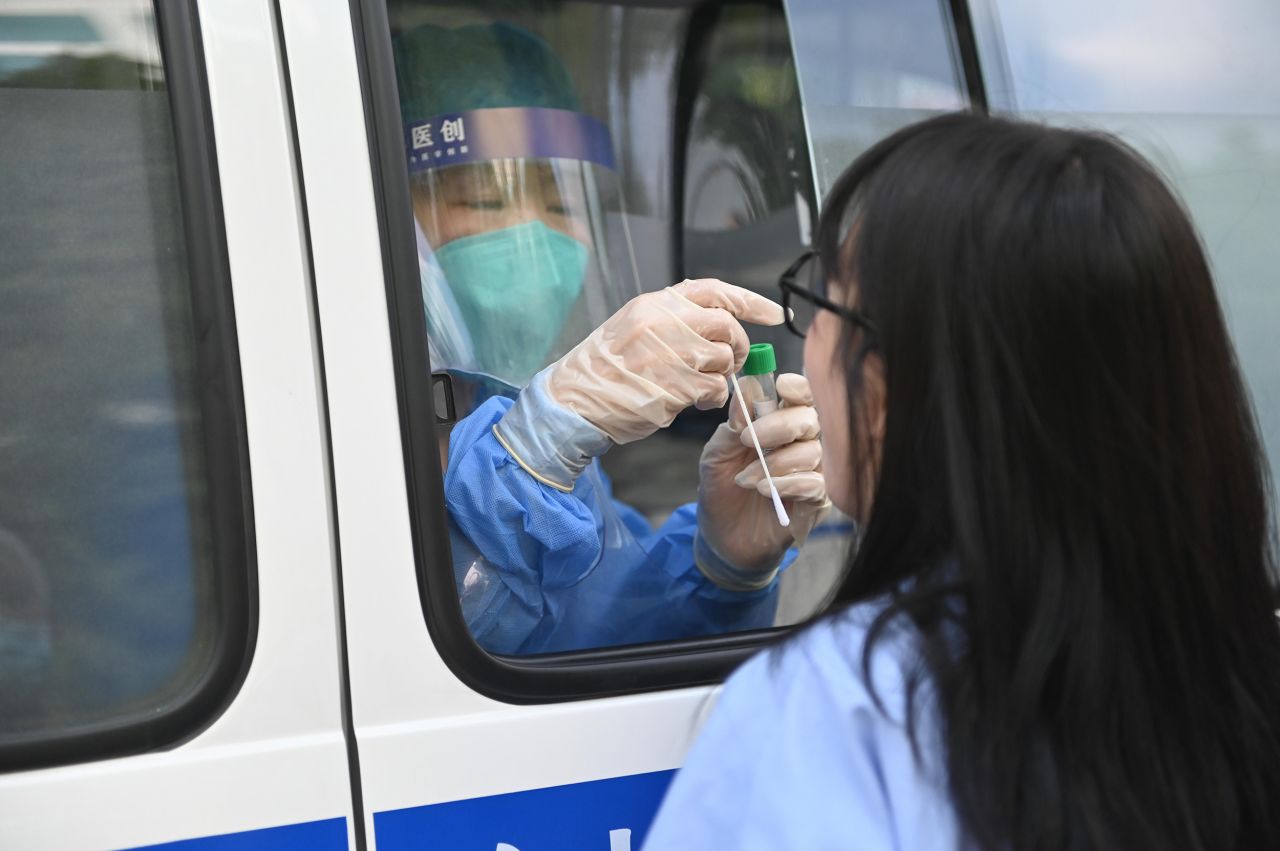 A medical worker collects a swab sample from a woman for a coronavirus test on July 28, in Shenyang, China. 