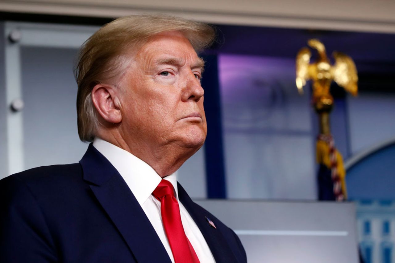 US President Donald Trump listens to Agriculture Secretary Sonny Perdue speak at the coronavirus briefing at the White House on Friday, April 17, in Washington. 