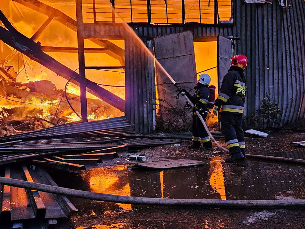 Firefighters work at a site of an industrial warehouse damaged by a Russian drone strike in Lviv, Ukraine, on Tuesday, September 19. 