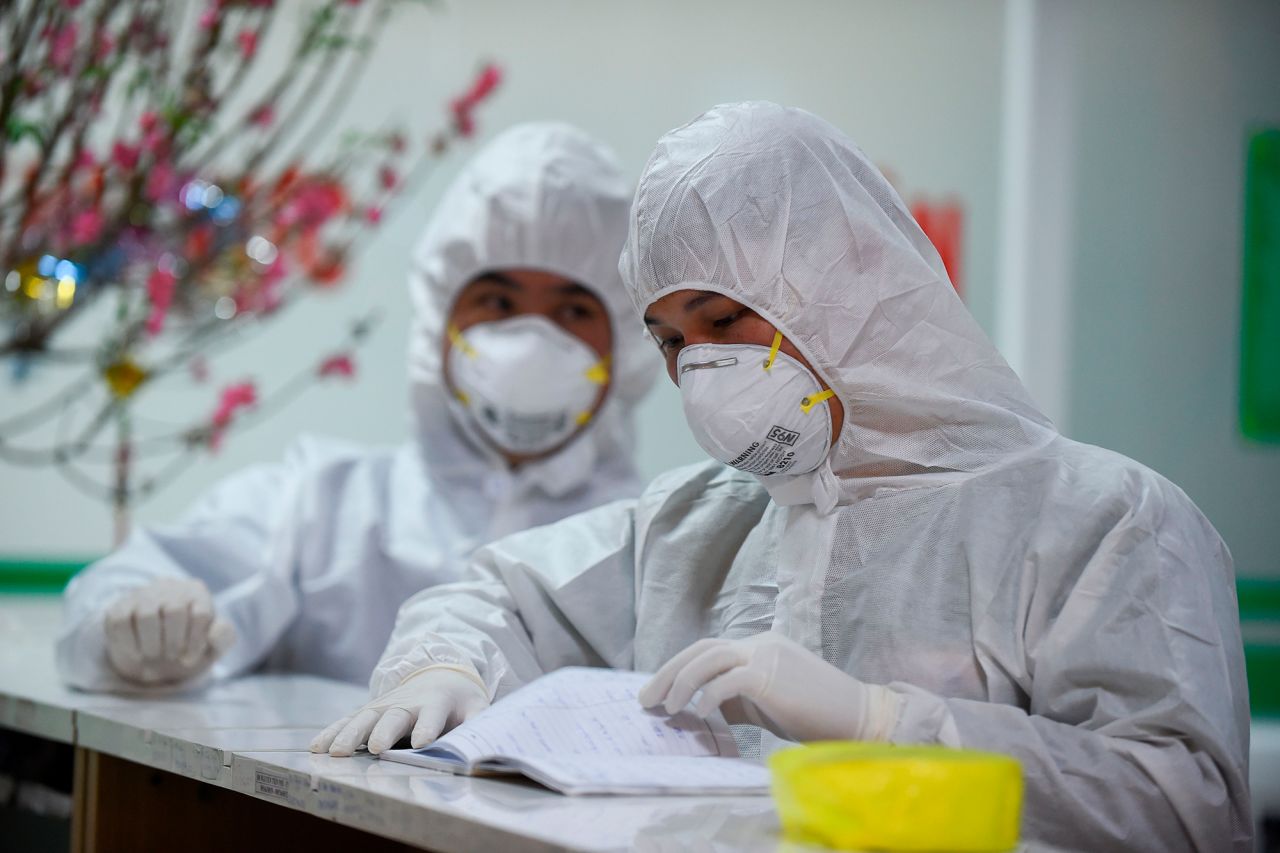 Medical workers check a notebook at an isolation area of the National Hospital of Tropical Diseases in Hanoi on January 30, 2020.