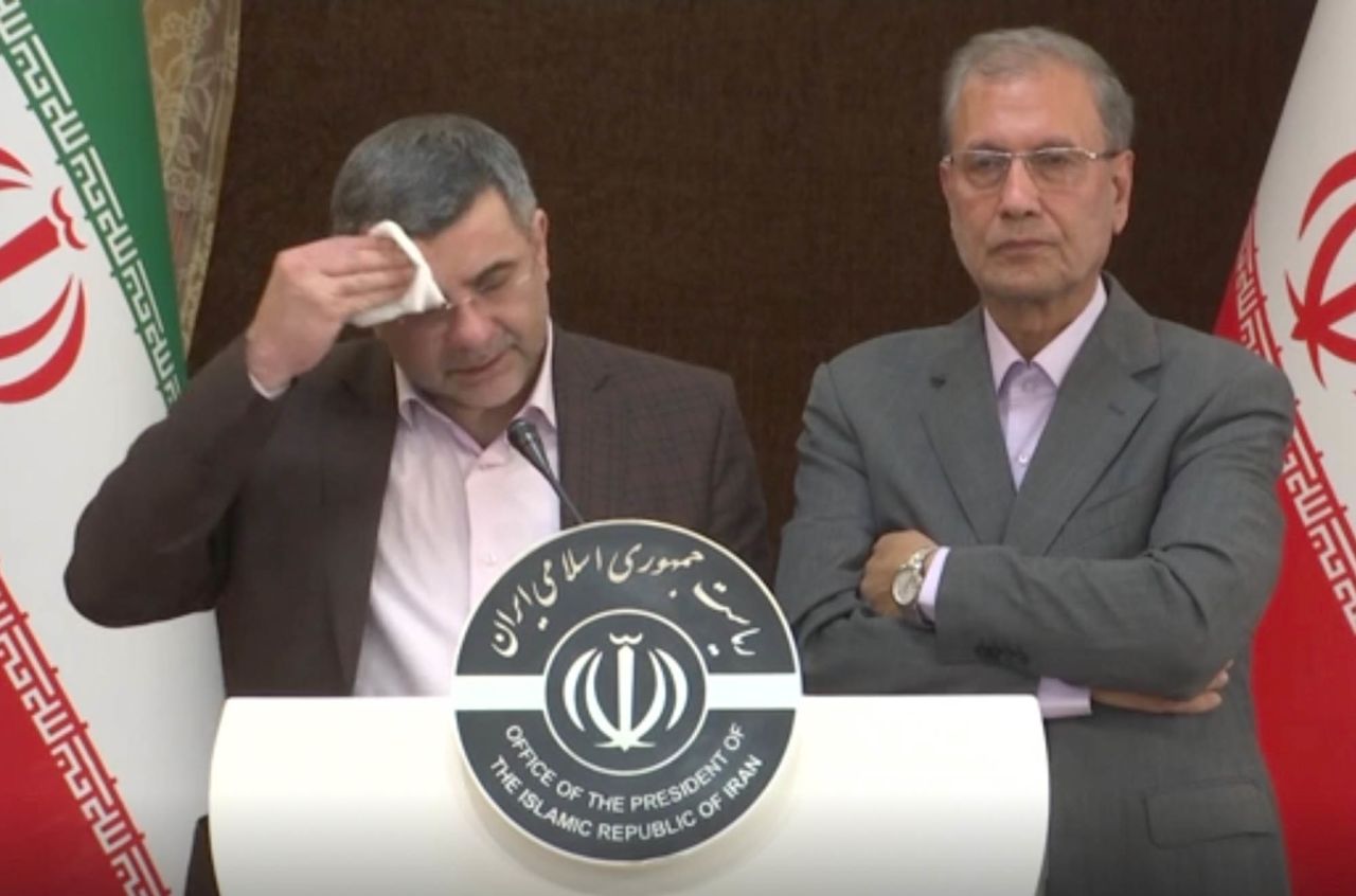 This image made from video shows the head of Iran's counter-coronavirus task force, Iraj Harirchi, left, wiping his face during a press briefing with government spokesman Ali Rabiei, in Tehran, Iran, on Monday. Harirchi, has tested positive for the virus himself, authorities announced on Tuesday, amid concerns the outbreak may be far wider than officially acknowledged.