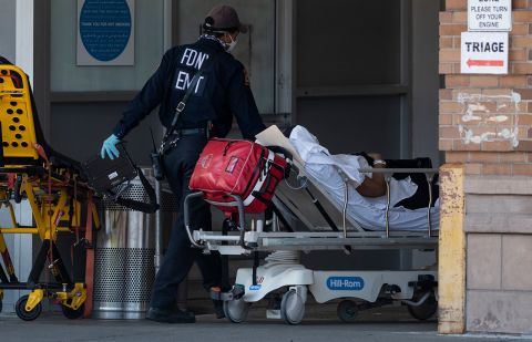 Medical workers transport a patient outside a special COVID-19 illness area at Maimonides Medical Center  in Brooklyn, New York on May 17.