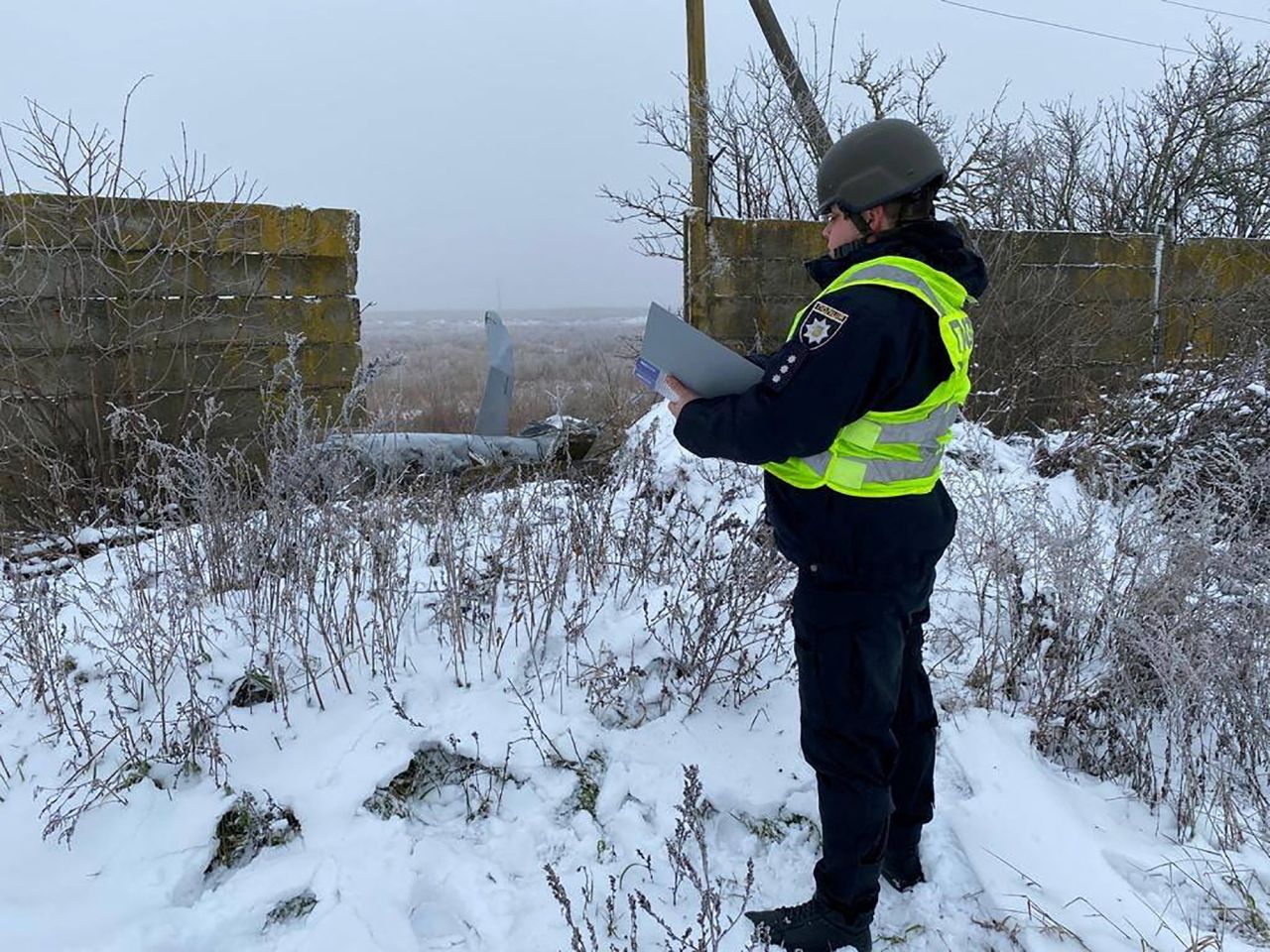 A police officer stands next to part of a Russian cruise missile shot down by the Ukrainian Air Defence Forces in the Kyiv region,?Ukraine, on?December 16.