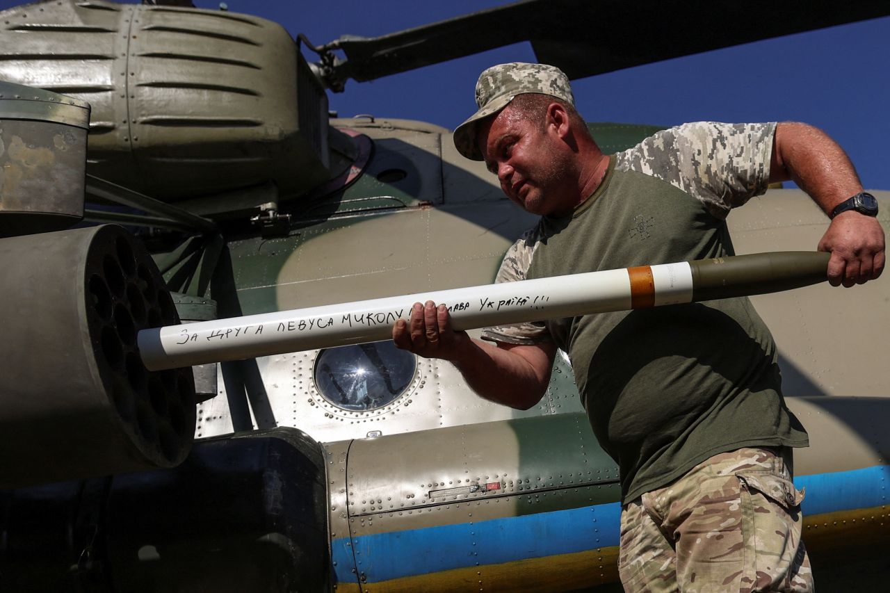 A Ukrainian serviceman loads unguided missiles into a launcher of a military Mi-8 helicopter in an undisclosed location in Eastern Ukraine, on September 29, 2023. The inscription on the missile reads: "For friend Mykolaiv Levis. Glory to Ukraine".