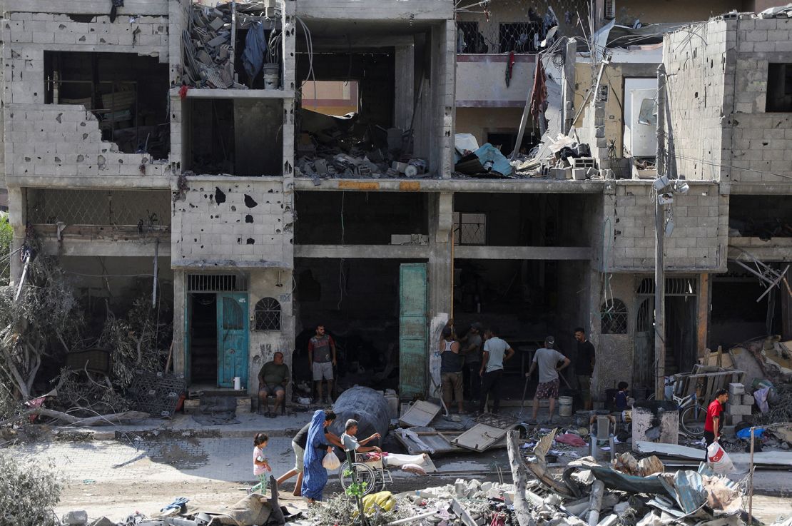 People walk among debris, aftermath of Israeli strikes at the area, where Israeli hostages were rescued on Saturday, in Nuseirat refugee camp in central Gaza, on Sunday, June .. 