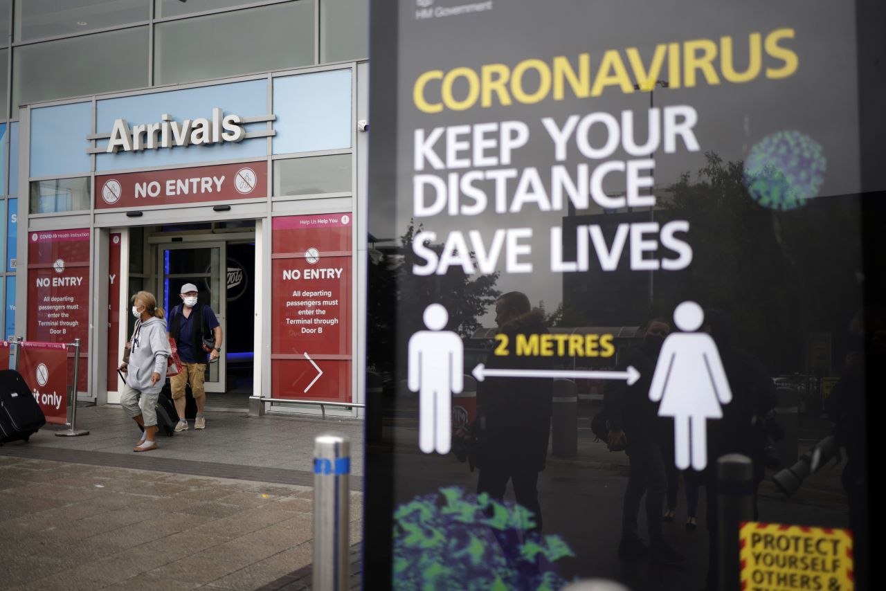 Passengers wearing protective masks exit the arrivals terminal at Birmingham Airport on July 27, 2020 in England.