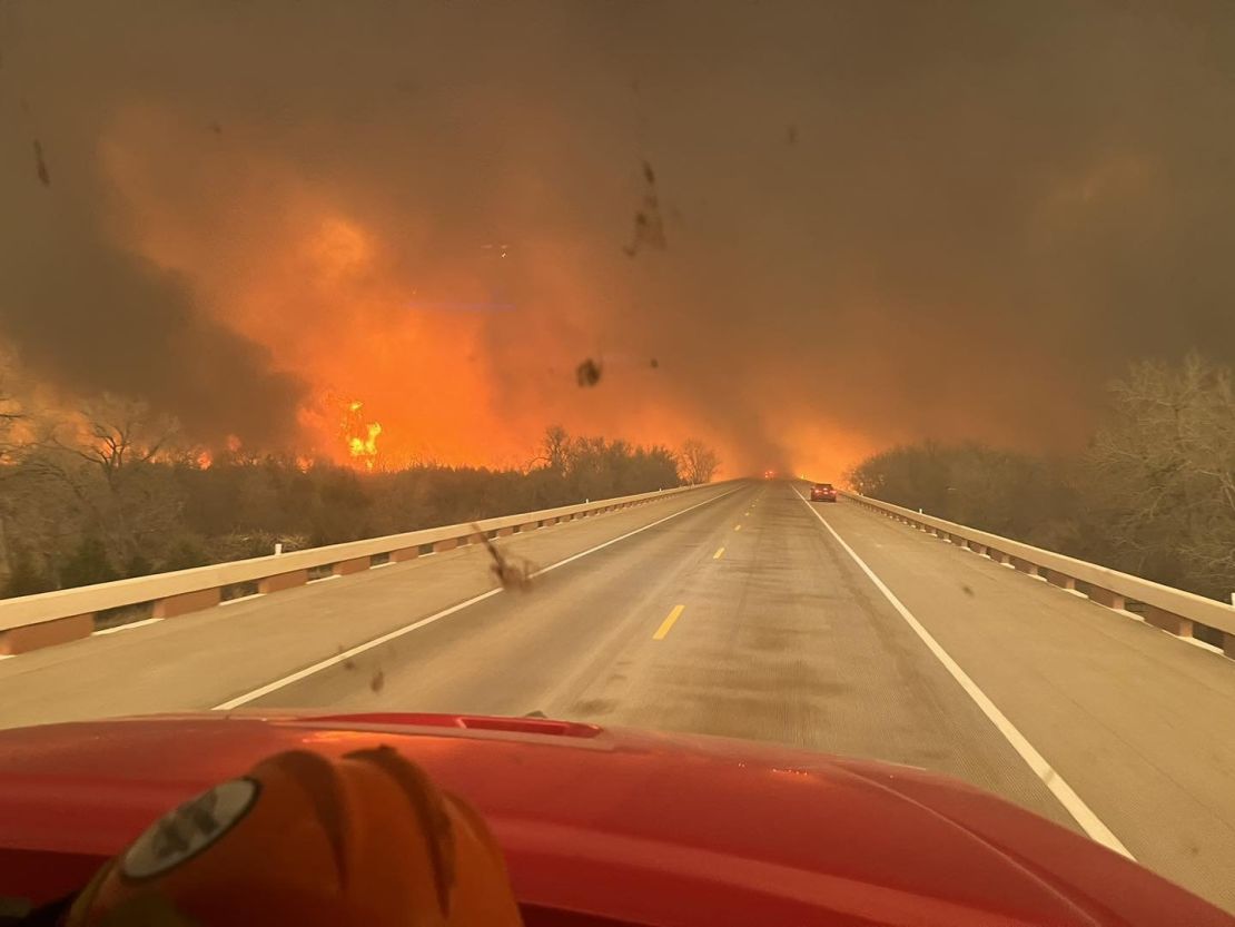 Greenville Fire-Rescue firefighters drive near the Smokehouse Creek Fire as it threatens the Texas towns of Canadian and Wheeler on Tuesday.