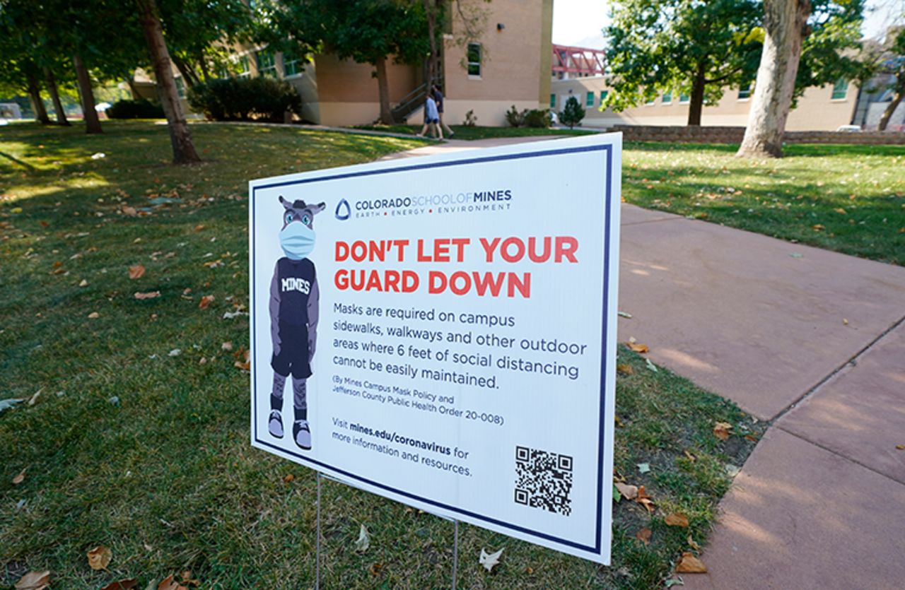 A sign stands along a walkway calling for students and instructors to avoid the new coronavirus at the Colorado School of Mines Wednesday, Sept. 30, 2020, in Golden, Colorado. 