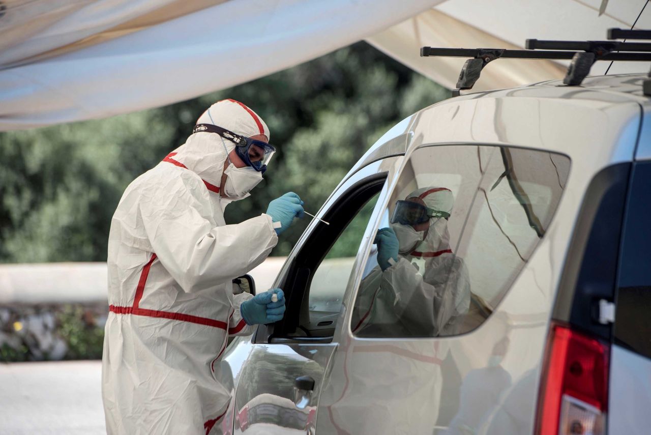 A health worker tests a patient at a drive-through testing center in Menorca, Spain, on April 6.