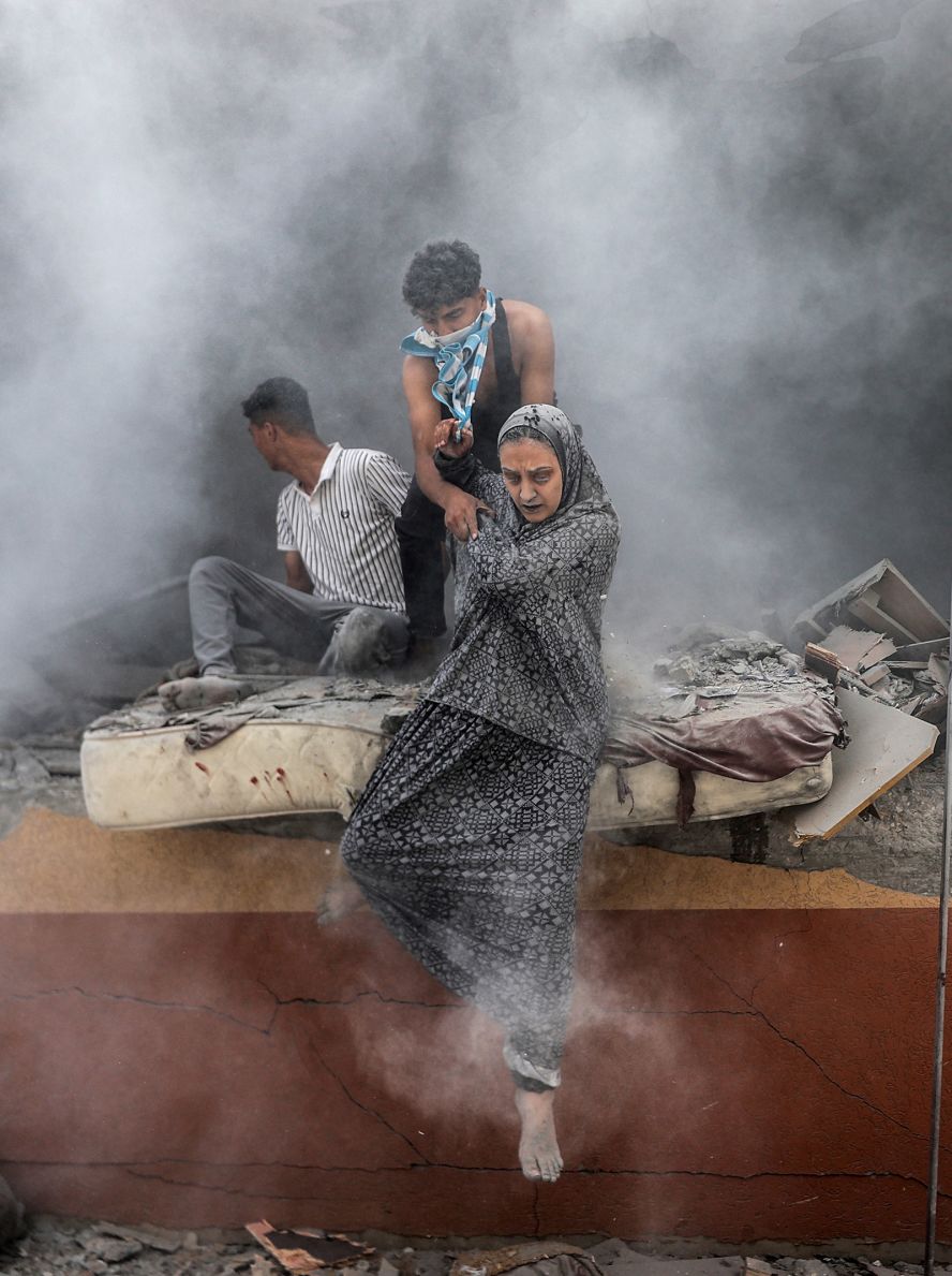 Palestinians walk out of rubble covered in dust after an Israeli attack in Deir al-Balah, Gaza, on June 14.