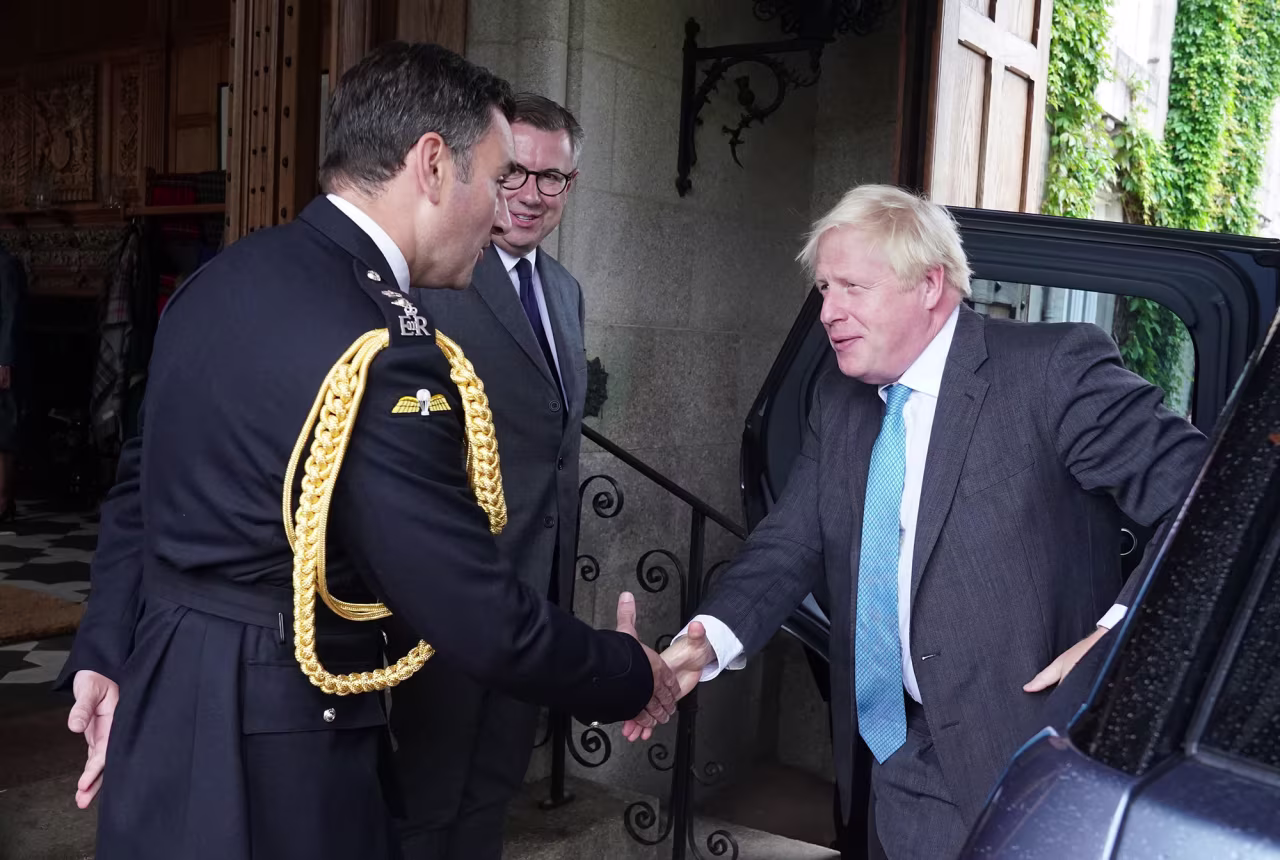 Outgoing Prime Minister Boris Johnson, right, is greeted by the Queen Elizabeth II's Equerry Lieutenant Colonel Tom White and her private Secretary Sir Edward Young as he arrives for an audience to formally resign as Prime Minister at Balmoral Castle on September 6, in Aberdeen, Scotland