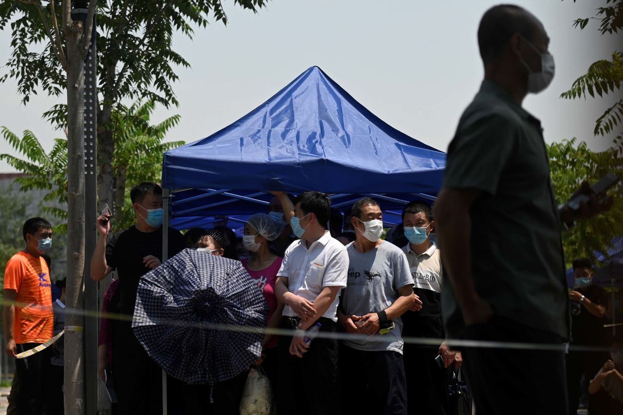 People wait to take a swab for COVID-19 at a testing site in Beijing on June 18.