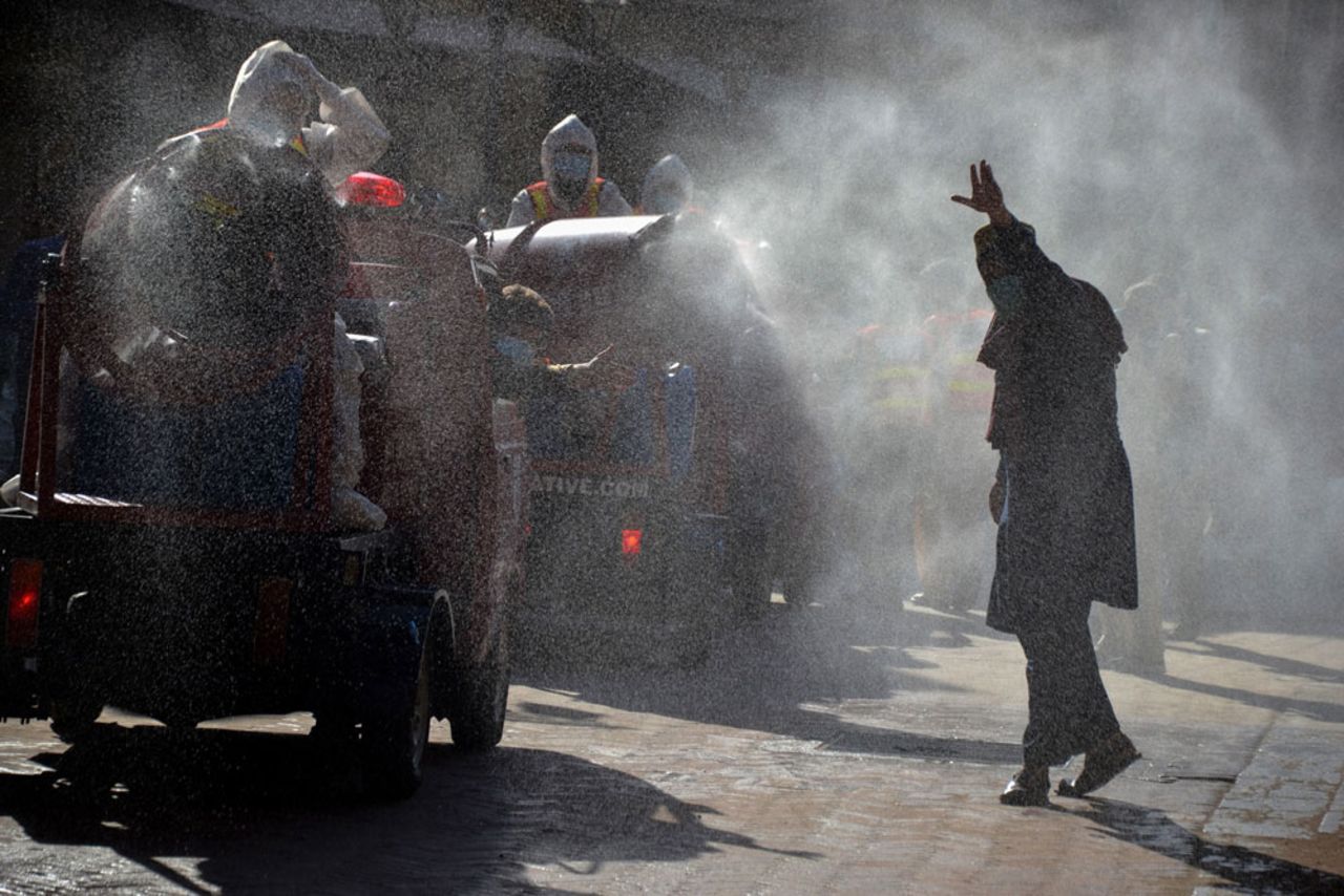 Rescue workers spray disinfectant along a road in Peshawar on May 6.