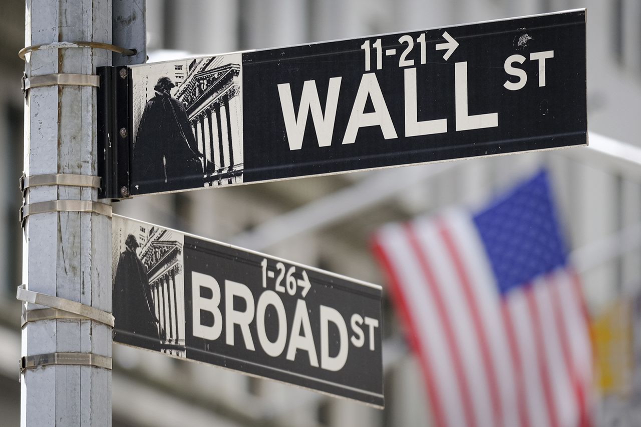 A U.S. Flag hangs in the background at the corner of Wall and Broad Streets in the heart of the Financial District in New York City, Tuesday, Aug. 1.