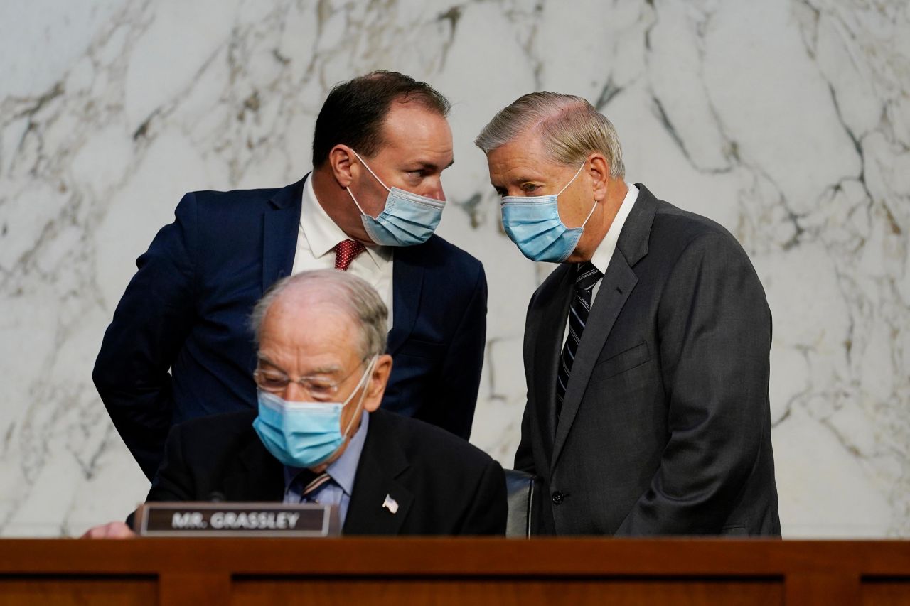 Senate Judiciary Committee Chairman Sen. Lindsey Graham, standing right, talks to Sen. Mike Lee, R-Utah., as Sen. Charles Grassley, R-Iowa, sits below.