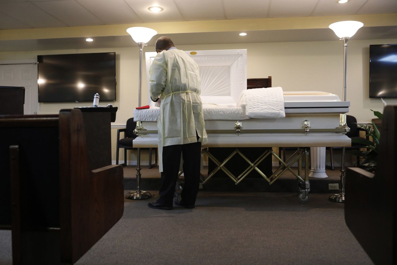 Jeffrey Rhodes, a funeral home director applies makeup for man who died of COVID-19 before his funeral at Ray Williams Funeral Home on August 12, in Tampa, Florida. 