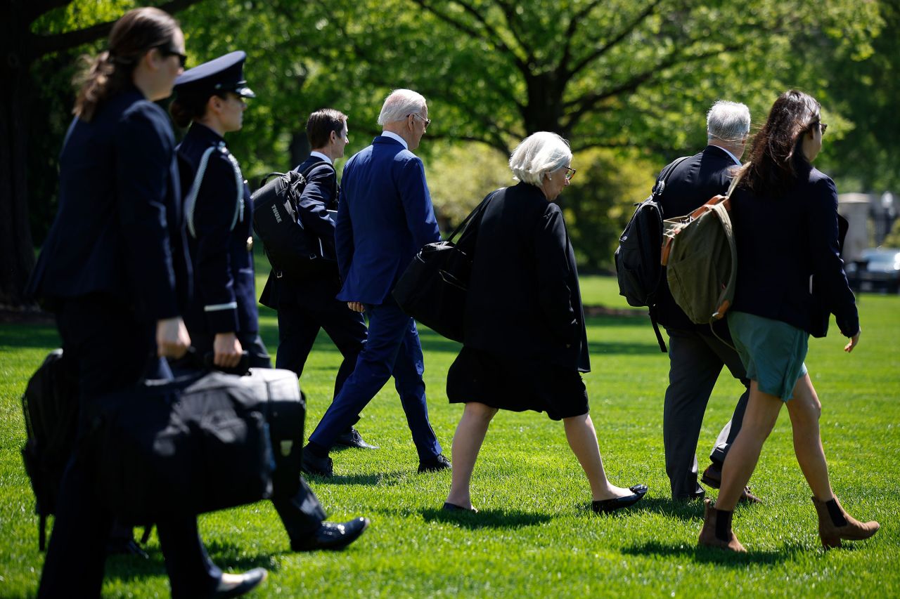 President Joe Biden is accompanied by senior advisors Anita Dunn, center, as they depart the White House on April 23 in Washington, DC.