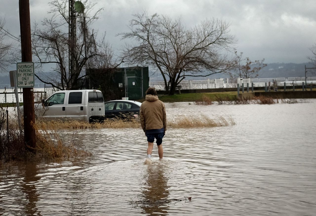 A man wades through flood waters to attempt to retrieve his truck along the Hudson River in Piermont, New York, on December 23.