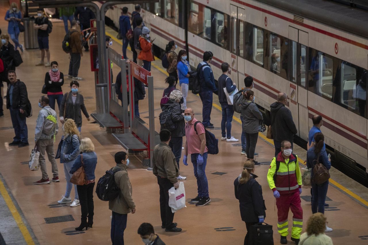 Commuters wear face masks to protect against coronavirus on a platform at Atocha train station in Madrid, Spain, on Monday, May 4. 