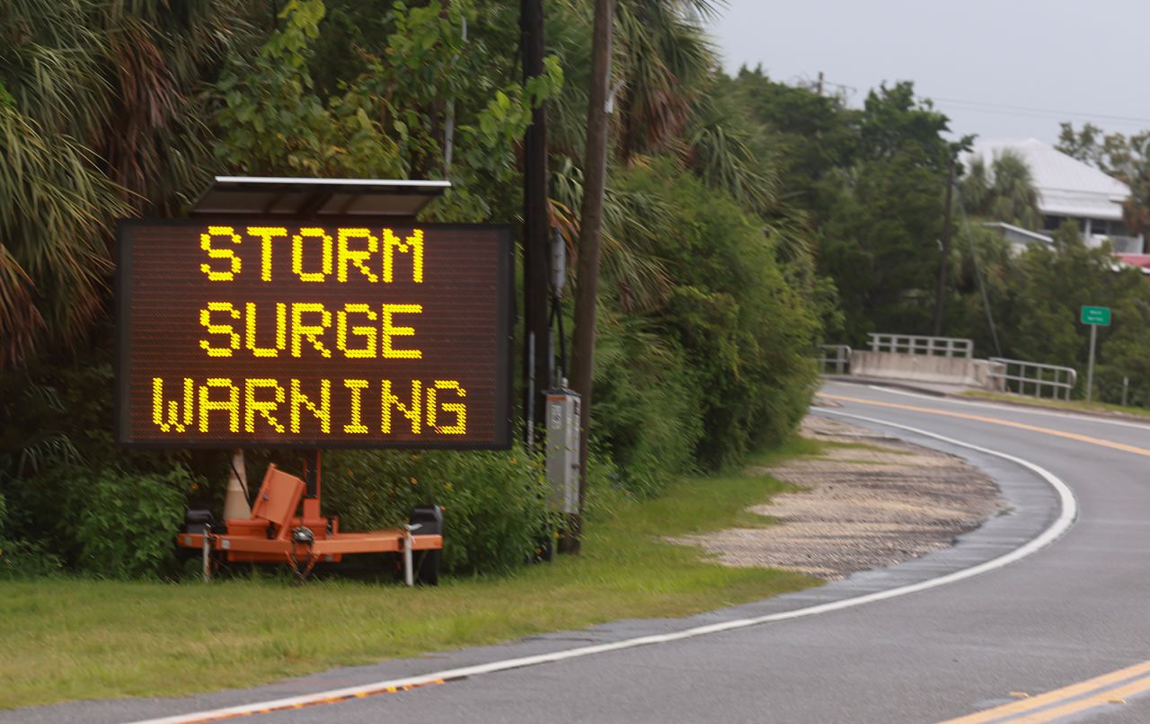 A sign warns of a storm surge before the possible arrival of Debby, in Cedar Key, Florida on August 4.