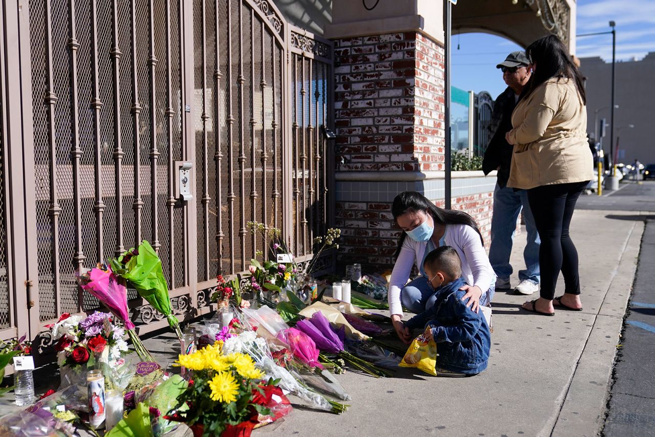 People pay their respects Monday at a makeshift memorial outside the Star Ballroom Dance Studio in Monterey Park.