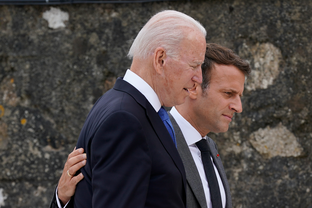 President Joe Biden speaks with French President Emmanuel Macron after posing for the G-7 family photo with guests at the G-7 summit on Friday.