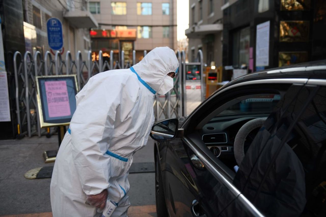 A security guard prepares to take the temperature of an arriving customer at a restaurant in Beijing on Wednesday. 