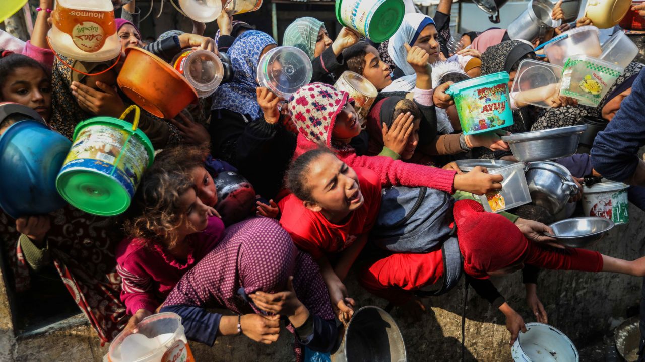 People wait for food in Rafah, Gaza, in late December. Officials have reported that nearly all families in Gaza are skipping meals due to food shortages.