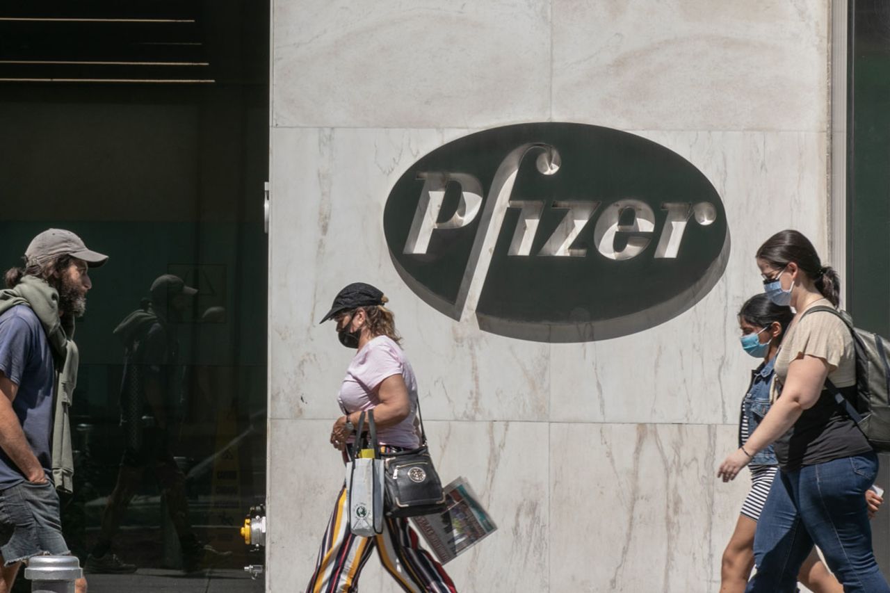 Pedestrians wearing protective masks walk past Pfizer Inc. headquarters on July 22 in New York City, New York.