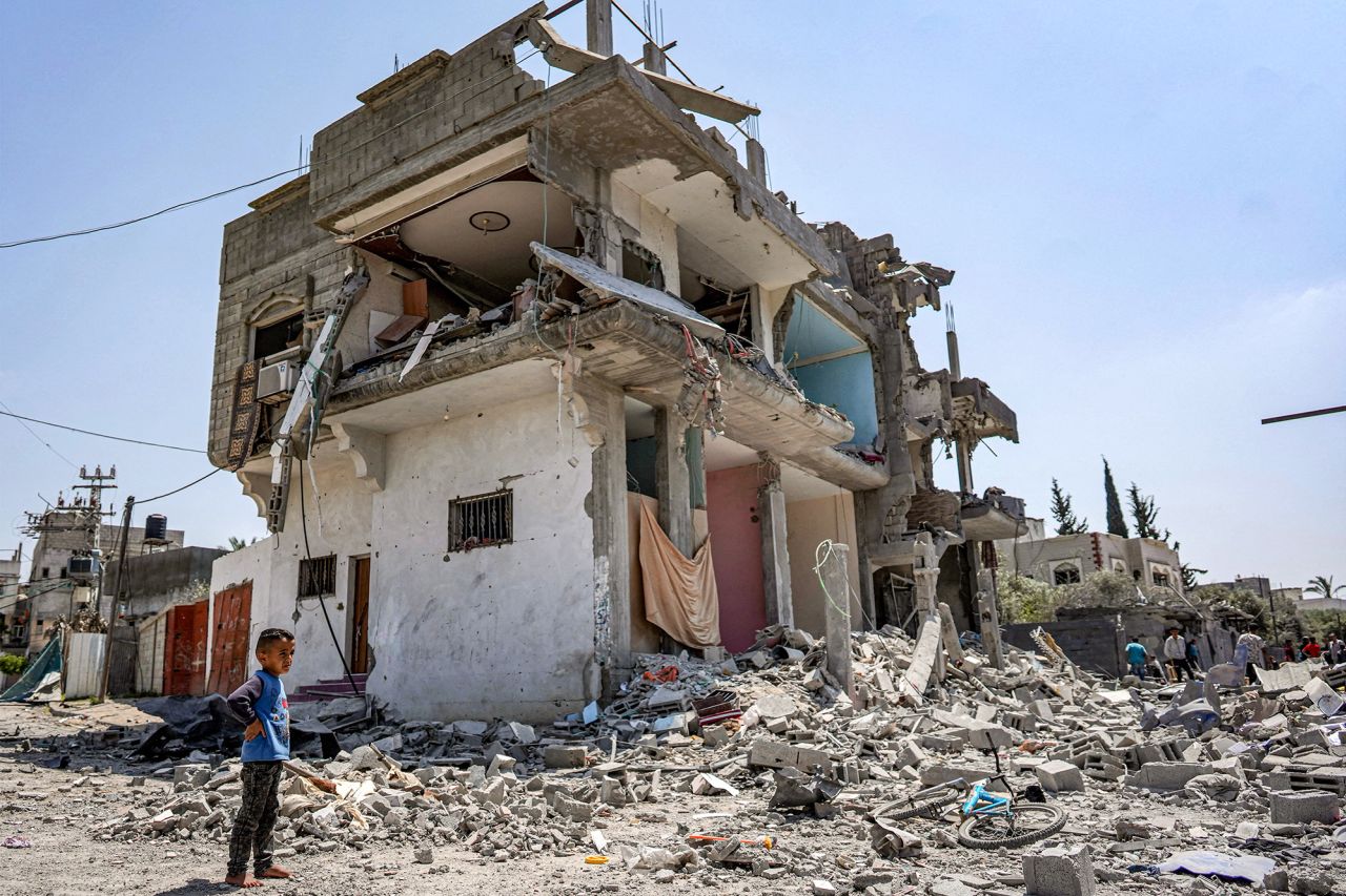 A boy stands by rubble around a heavily damaged building at the Al-Maghazi refugee camp in Gaza, on April 15.