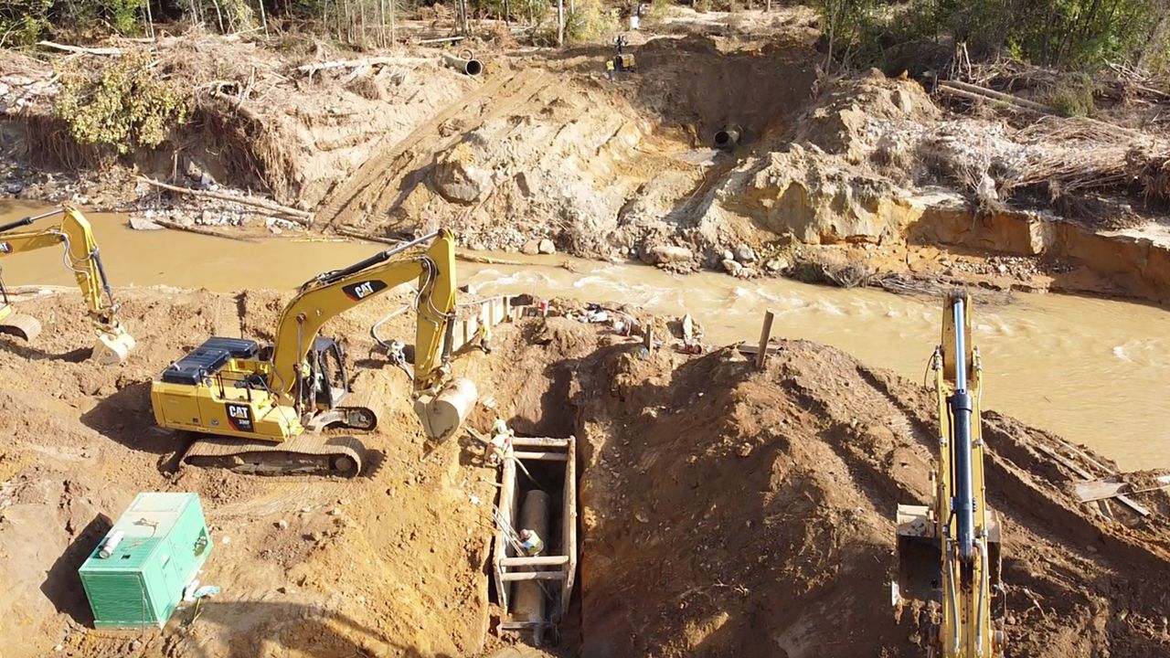 Workers are seen repairing a water main leading into Asheville, North Carolina, in a photo released on October 7.