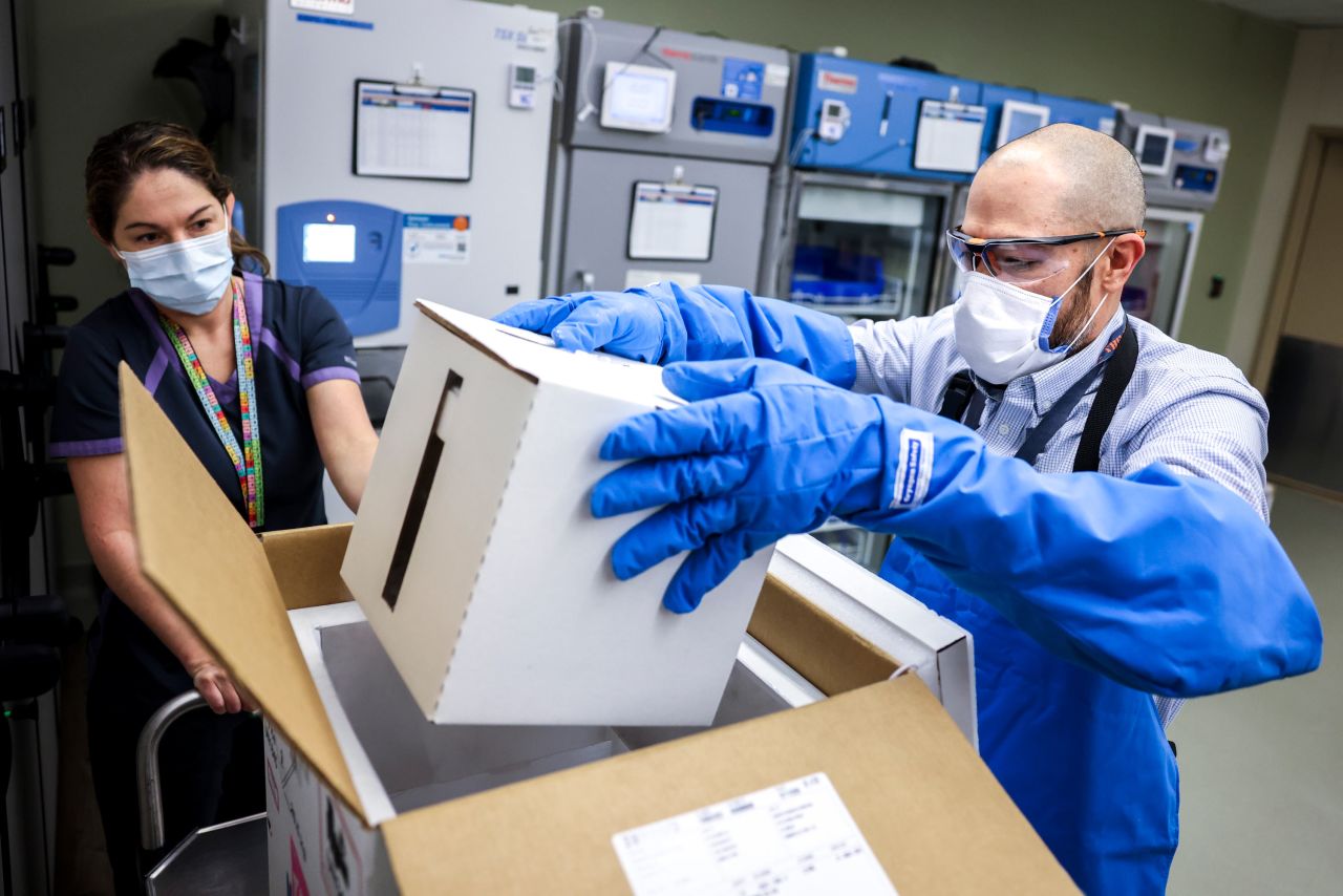 Rocky Mountain Regional VA Medical Center associate chief of pharmacy operations Terrence Wong opens a box containing a shipment of the Pfizer-BioNTech COVID-19 vaccine on December 15, 2020 in Aurora, Colorado.