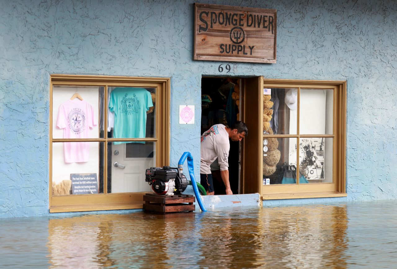 A store owner uses a sump pump to try to keep water out of his store in Tarpon Springs.