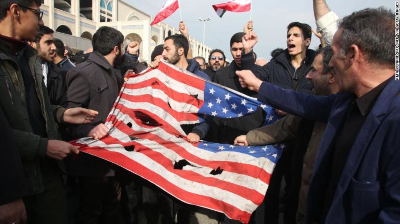 Iranians tear up a US flag during a demonstration in Tehran on January 3, 2020.