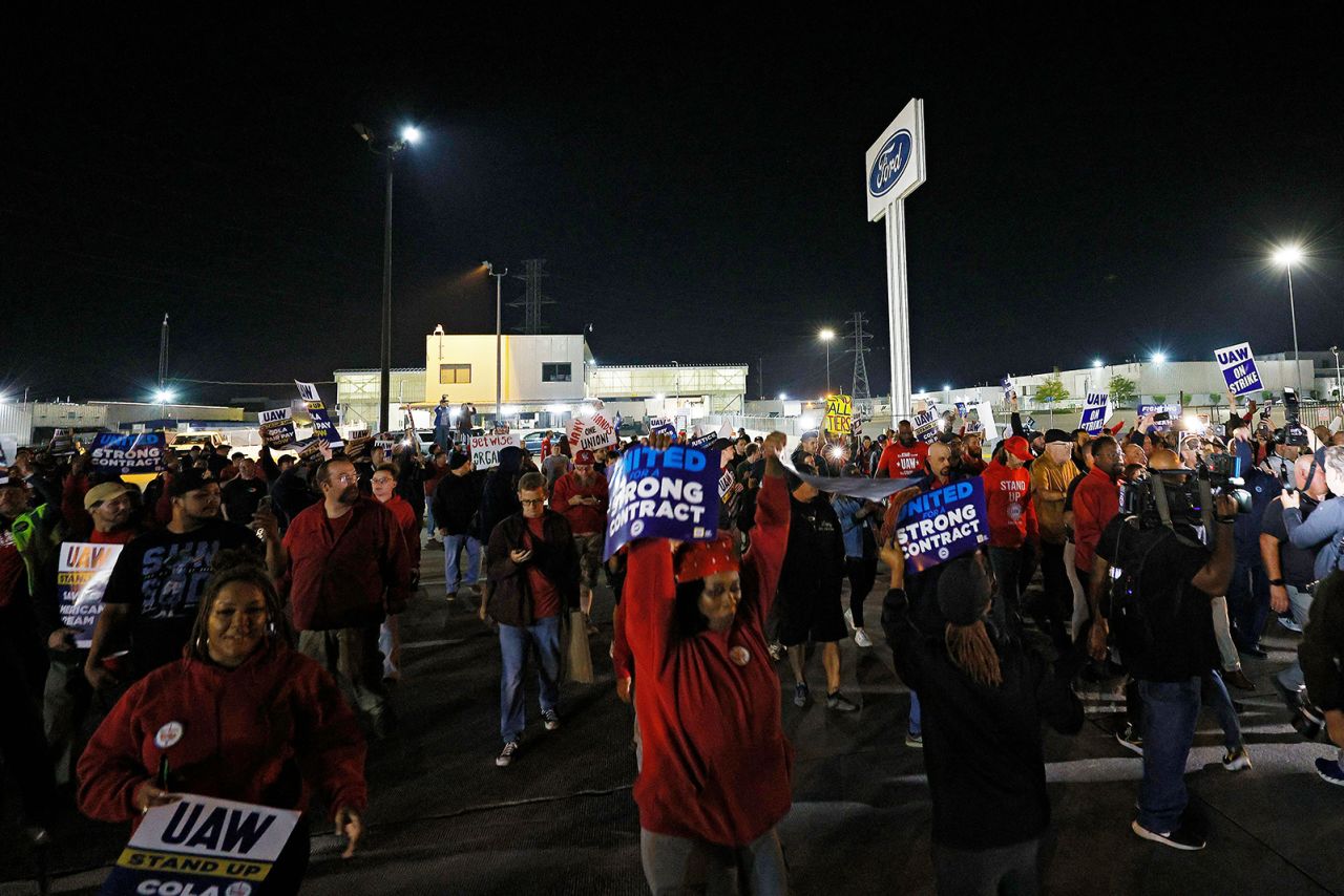 Members of the United Auto Workers union (UAW) strike outside of the Ford Michigan assembly plant in Wayne, Michigan, earlier today. 