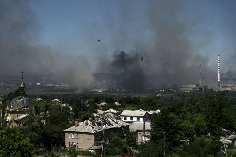 A damaged building is pictured in Lysychansk as black smoke and dirt rise from the nearby city of Severodonetsk during battle between Russian and Ukrainian troops in the eastern Ukraine region of Donbas, on Thursday.