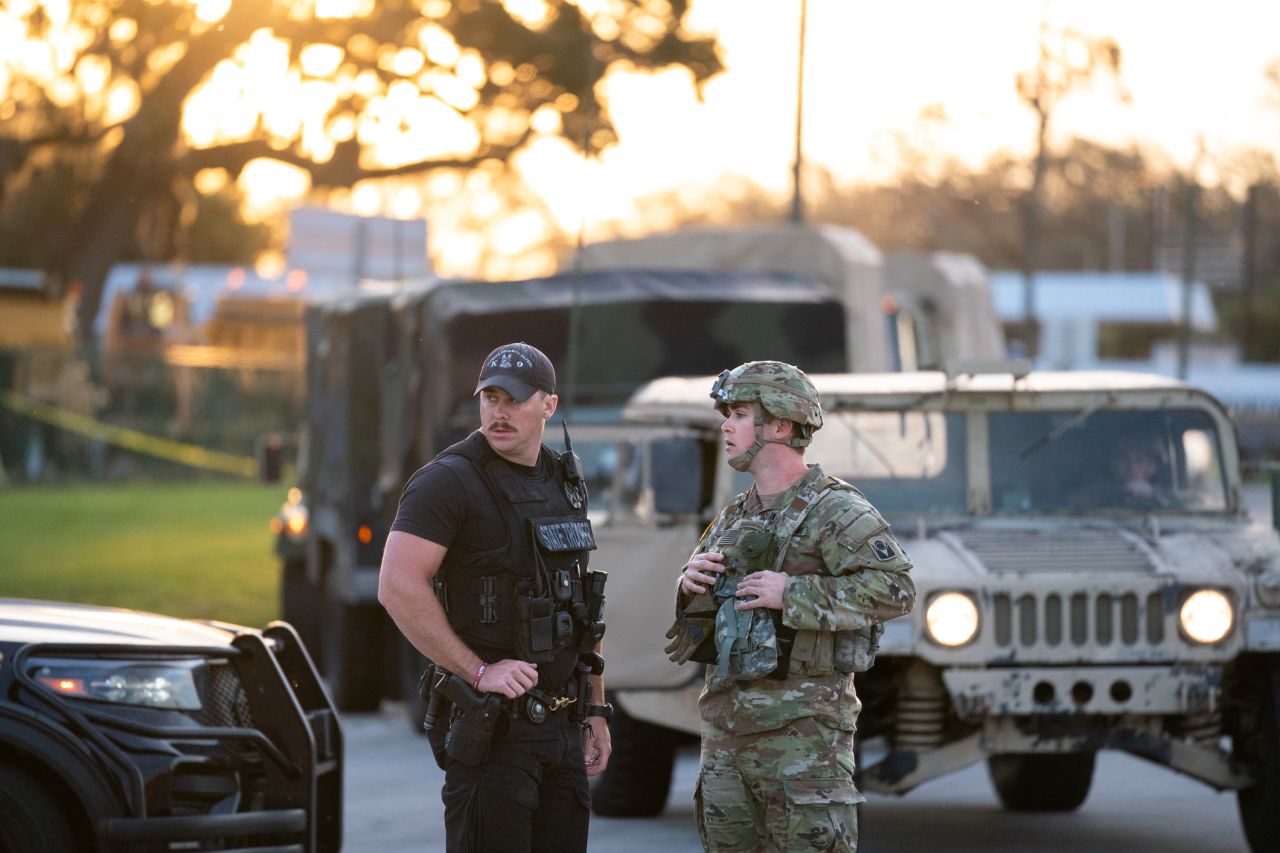 A state trooper and national guardsman work together near flooding from the Peace River on October 4 in Arcadia, Florida.?