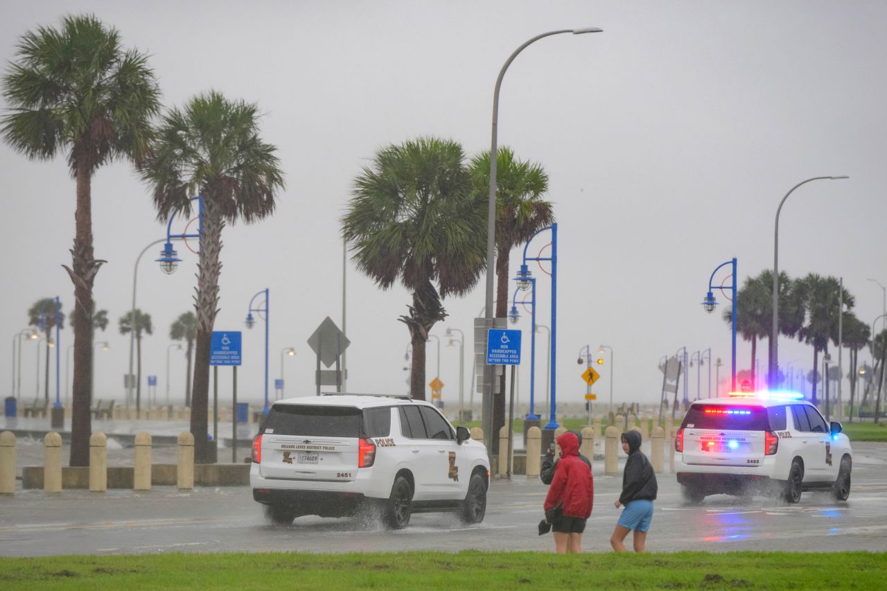 People watch Orleans Levee District Police patrol on Lakeshore Drive along Lake Ponchartrain in New Orleans, on September 11.