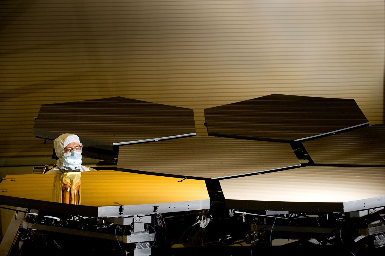 Ball Aerospace optical technician Scott Murray inspects the first gold primary mirror segment, a critical element of NASA's James Webb Space Telescope, prior to cryogenic testing in the X-ray & Cryogenic Facility at NASA's Marshall Space Flight Center in Huntsville, Alabama.